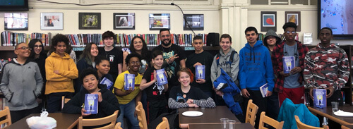 Author Mark Oshiro pictured with students holding his book Anger is a Gift