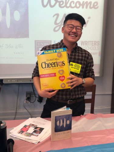 Photo of poet Yanyi holding a box of Cheerios