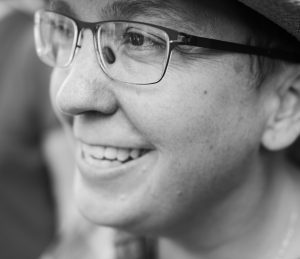 Gay American-Canadian author Karleen Pendleton Jiménez in black and white with light skin tone, dark hair, dark eyes, and glasses.